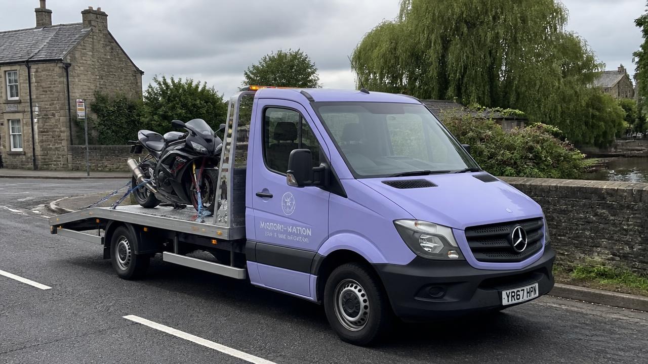 Motorbike strapped safely on a flatbed recovery truck