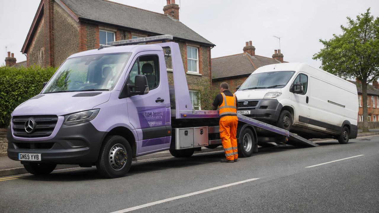 White van being winched onto a 3.5t flatbed recovery truck